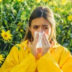 Woman sneezing from allergies next to flowers in Orlando, FL
