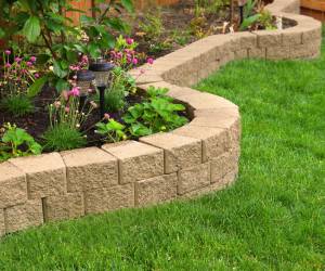 Curved brick retaining wall next to lush green lawn