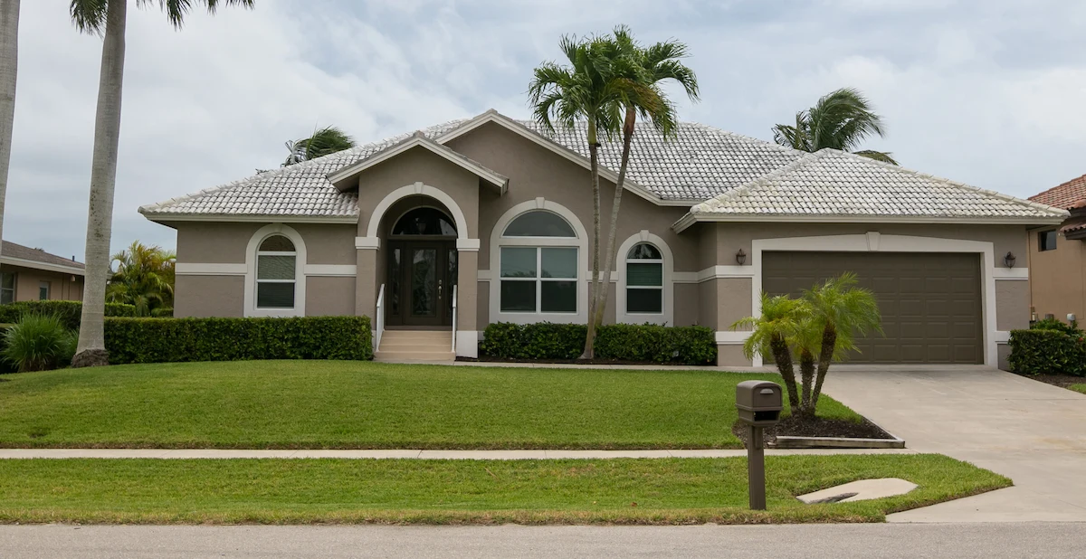 Front view of a stucco house and green front yard in Orlando, FL